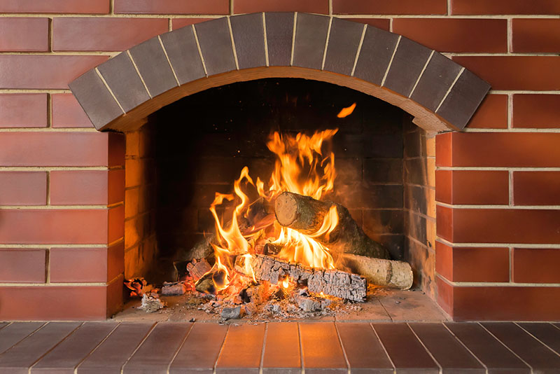 Lit fireplace with brick surround