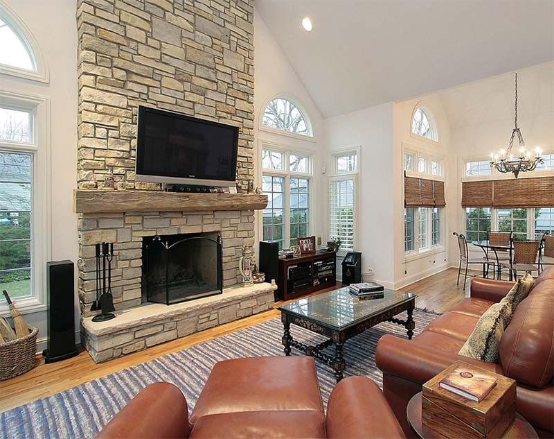 Living room with a grey stone surround and wooden mantelpiece 